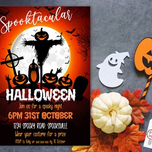 May include: A Halloween-themed invitation with a spooky design. The invitation features a full moon, bats, and jack-o'-lanterns. Text on the invitation reads "Spooktacular Halloween" and includes event details. A white ghost and pumpkin decoration are also visible.