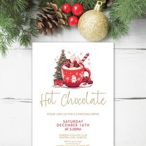 Op de afbeelding: Een kerstuitnodiging met een illustratie van een rode warme chocolademok. De woorden "Hot Chocolate" staan in gouden letters. De uitnodiging bevat details voor een kerstdrankje op 16 december.