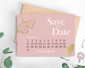 May include: A pink "Save the Date" card with gold leaf accents and a calendar highlighting September 14. The card includes the names "Dean & Sarah" and is accompanied by a peach envelope and a tag.