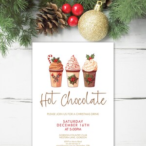 May include: A Christmas-themed invitation with the words "Hot Chocolate" in a decorative font. The invitation features illustrations of three hot chocolates and event details, including the date, time, and location.