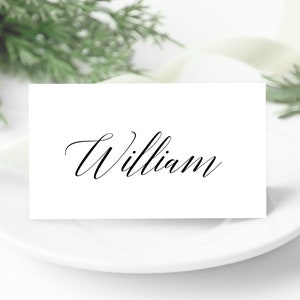 May include: White place card with the name "William" written in black cursive script.