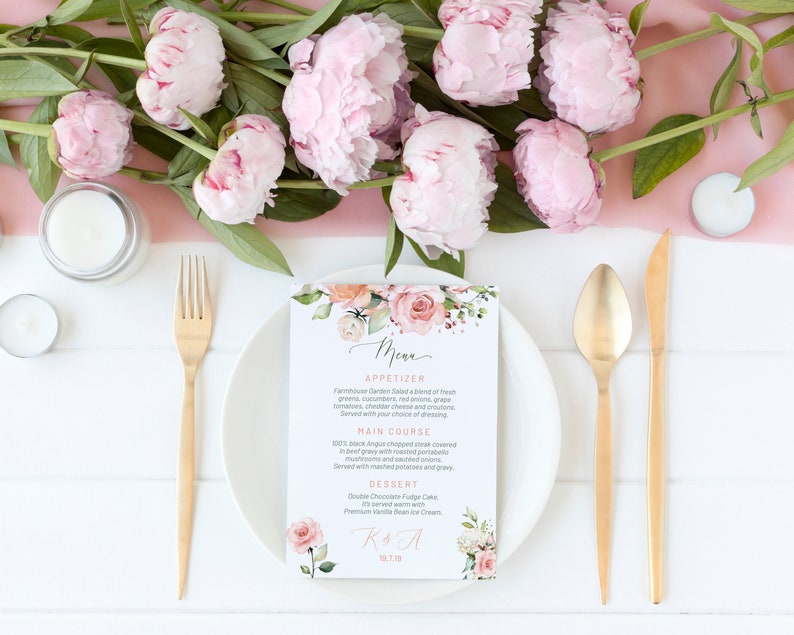 May include: A wedding menu card with a floral design featuring pink and peach flowers. The menu includes appetizers, main course, and dessert. The card also includes the couple's initials and wedding date.