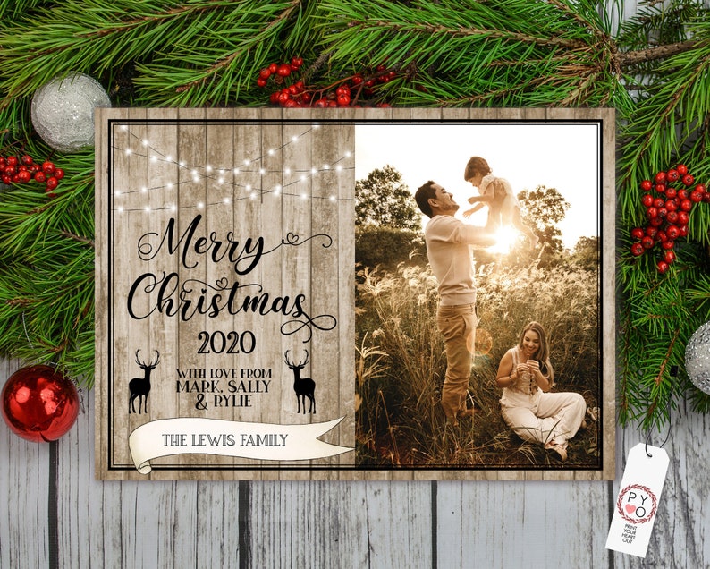 May include: A wooden Christmas sign with the text "Merry Christmas 2020" and a family photo. The sign includes the family's name and deer silhouettes. Festive greenery and ornaments surround the sign.