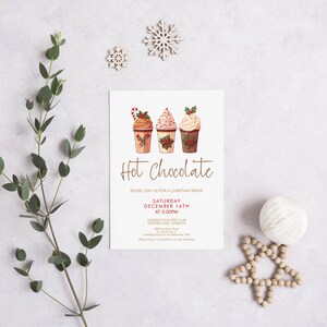 May include: A Christmas-themed invitation with three illustrated hot chocolate cups, topped with whipped cream and festive decorations. The words "Hot Chocolate" are written in elegant script. Decorative elements include snowflakes and greenery.