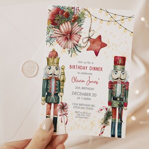 Op de afbeelding: Een aquarel verjaardagsdiner uitnodiging met twee notenkraker figuren, zuurstokken en feestelijke decoraties. De uitnodiging bevat de tekst "Kom met ons mee voor een verjaardagsdiner om Olivia Jones' 35e verjaardag op 20 december om 19:00 uur te vieren."