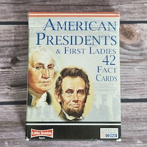 May include: A rectangular box of American Presidents & First Ladies 42 Fact Cards. The front features portraits of George Washington and Abraham Lincoln, with the text Little Debbie Snacks and American Presidents C-SPAN logos at the bottom.