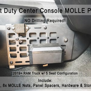 May include: A gray metal Light Duty Center Console MOLLE Panel for 2019+ RAM Truck with 5 seat configuration. The panel features a grid pattern, includes a black storage box, brackets, 8x MOLLE nuts, panel spacers, and hardware. Text reads: NO Drilling Required!