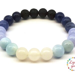 Könnte beinhalten: Ein blaues, weißes und schwarzes Edelstein-Armband mit einem Farbverlauf. Das Armband besteht aus runden Perlen und hat ein elastisches Band.