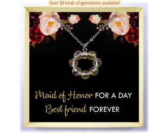 Puede incluir: Una caja dorada con fondo negro y diseño floral. Dentro de la caja hay un collar de plata con un colgante de cristal que dice "Maid of Honor for a Day Best Friend Forever".