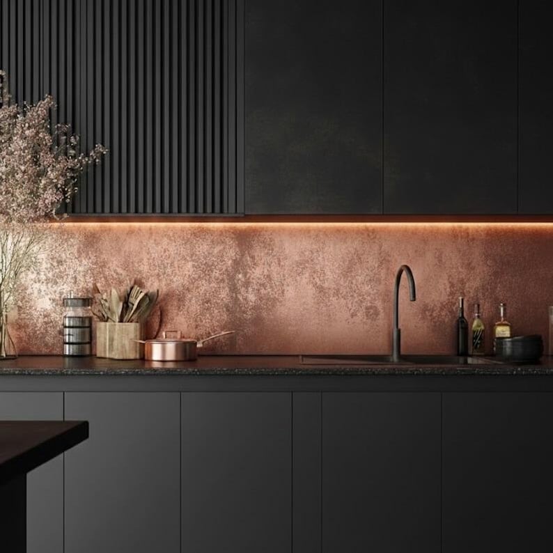Copper backsplash installed in all-black kitchen, with matte black cabinets