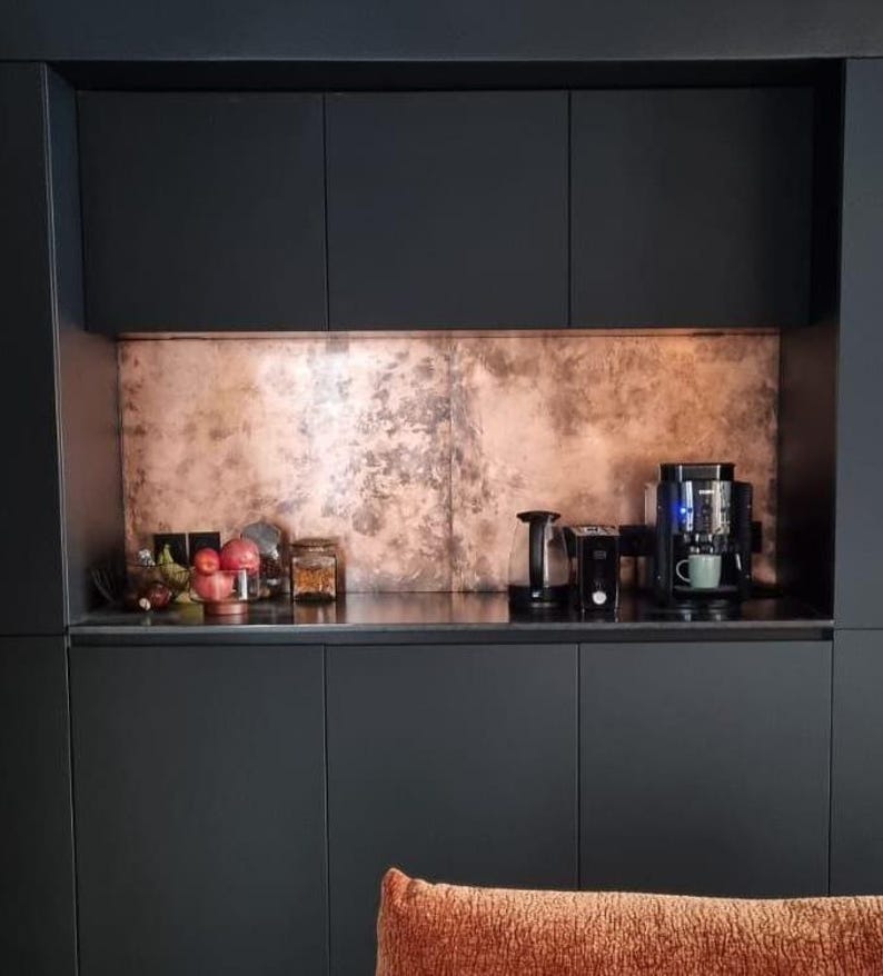 Copper splashback recessed in a coffee bar with matte black cabinets