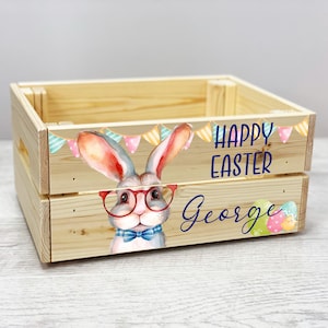 May include: A wooden crate featuring a bunny wearing glasses and a bow tie. The crate is decorated with colourful bunting and the text "Happy Easter George".