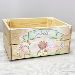 May include: A wooden crate with a personalized design featuring a cartoon baby girl with balloons, flowers, and the name "Isabella".