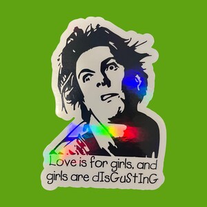 May include: A sticker with a black and white illustration of a person with a surprised expression. The sticker has a holographic effect and the text "Love is for girls, and girls are disgusting" in black.
