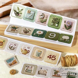 Puede incluir: Colección de pegatinas decorativas con diseños bordados de plantas, flores y números. Las pegatinas están dispuestas en formato rectangular, con una bobina de hilo de madera visible a la derecha. El texto "giftsmilee.com" es visible.