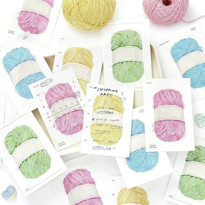 Peut inclure: Illustration de pelotes de laine colorées et de blocs-notes. La laine est représentée en rose, jaune, vert et bleu. Les blocs-notes présentent des dessins de laine et du texte manuscrit, dont "SHOPPING DAY!!" et une liste de courses.