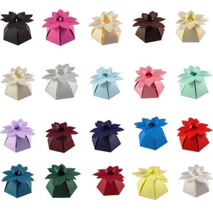May include: Twenty-four favour boxes in various colours, each with a flower-shaped top. The boxes are made of paper and are ideal for holding small gifts or treats.
