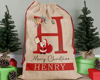 May include: A red and brown burlap Christmas stocking with a large red letter "H" and a Santa Claus illustration. The stocking is personalized with the text "Merry Christmas HENRY".