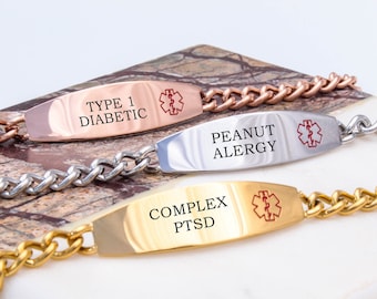 May include: Three gold, silver, and rose gold medical alert bracelets with engraved text. The bracelets feature a chain link design and a rectangular tag with the text "Type 1 Diabetic", "Peanut Allergy", and "Complex PTSD".