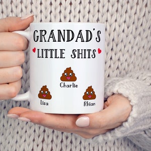 May include: White ceramic mug with the text "Grandad's Little Shits" and three poop emojis with the names "Lisa", "Charlie", and "Rhian" underneath.