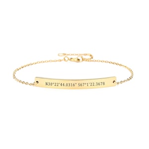 May include: A gold chain bracelet with a bar charm engraved with the coordinates "N30&deg;22'44.0316" S67&deg;1'22.3678".