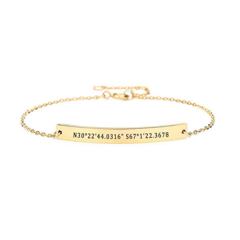 May include: A gold chain bracelet with a bar charm engraved with the coordinates "N30&deg;22'44.0316" S67&deg;1'22.3678".