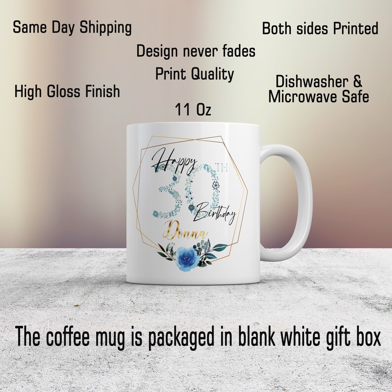 Może przedstawiać: Biały ceramiczny kubek do kawy z złotą geometryczną ramką i niebieskim wzorem kwiatowym. Kubek ma napis "Happy 30th Birthday Donna".
