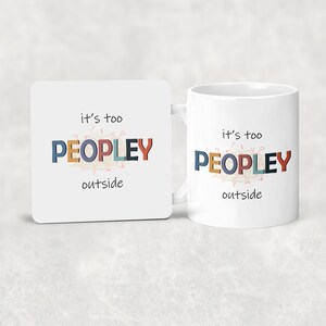 May include: A white ceramic mug and matching square coaster. Both feature the phrase "it's too PEOPLEY outside" in colorful block letters and a whimsical font. The mug has a handle and the coaster is square.