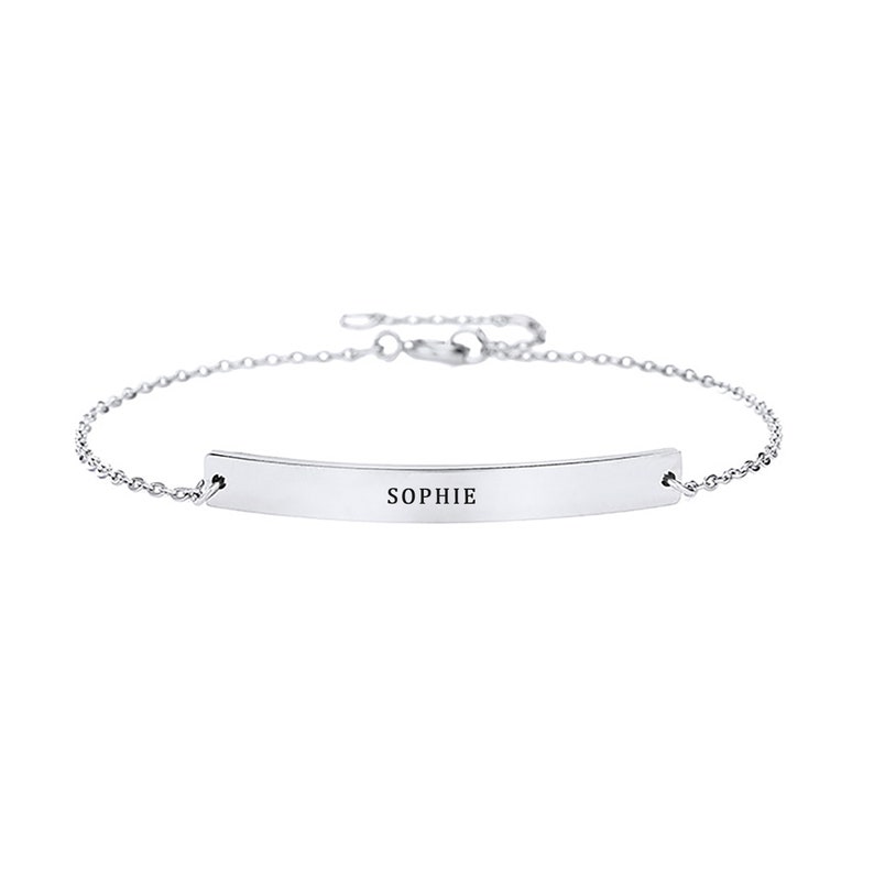 May include: A silver chain bracelet with a thin, curved bar charm engraved with the name "SOPHIE".