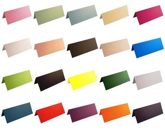May include: Twenty-four place cards in various colors, including pink, green, blue, brown, yellow, red, purple, orange, and beige. The cards are folded in half and have a triangular shape.