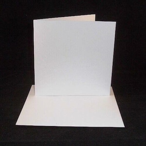 May include: Two blank white cards, one on top of the other. The top card is slightly offset to the right.