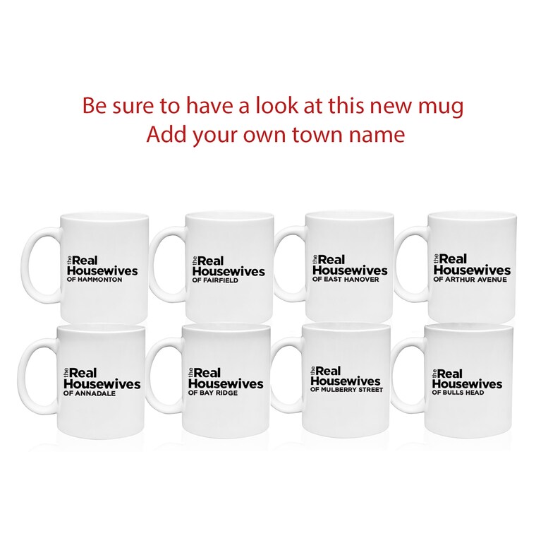 May include: Eight white coffee mugs with black text that reads "The Real Housewives of" followed by the name of a town. The towns are Hammonton, Fairfield, East Hanover, Arthur Avenue, Annandale, Bay Ridge, Mulberry Street, and Bulls Head.