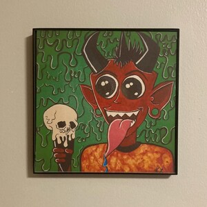 May include: A red cartoon devil with horns and a large tongue holds a white skull in its hand. The devil is set against a green background with dripping green paint.