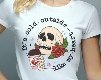 May include: White t-shirt with a skull and roses graphic and the text "It's cold outside - like my heart".
