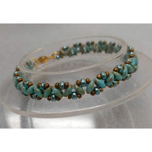 May include: A turquoise and gold beaded bracelet with a gold clasp. The bracelet is made with small, irregular shaped beads.