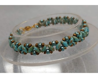 May include: A turquoise and gold beaded bracelet with a gold clasp. The bracelet is made with small, irregular shaped beads.