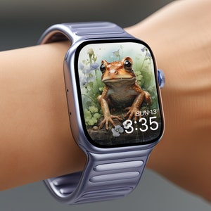Puede incluir: Un Apple Watch morado con una rana marrón en la pantalla. La esfera del reloj muestra la hora 3:35 y la fecha SUN 13.