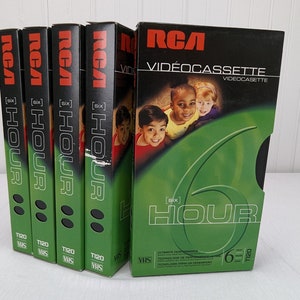 May include: A collection of RCA VHS videocassettes. The boxes are black and green, with the RCA logo in red. The text "[six] HOUR" is prominently displayed. The boxes feature images of children and the text "T120 VHS".