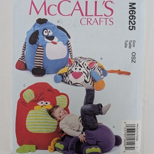 May include: A sewing pattern for making three different animal-shaped bean bag chairs. The pattern includes a blue dog, a zebra, and a red monkey. The pattern is from McCall's Crafts and is size OSZ.