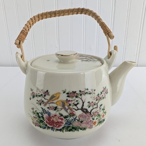 Peut inclure: Une tasse en céramique blanche avec une anse noire et le texte "But First, Coffee" en gras noir. La tasse est posée sur un fond flou. La tasse mesure environ 10 cm de hauteur.