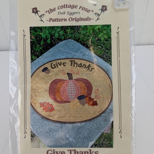 Op de afbeelding: Een quiltpatroon voor een ronde tafeltopper met een pompoen met de tekst "Give Thanks". Het patroon is van "the cottage rose" van Deb Eggers.