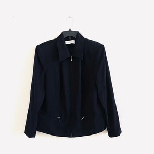 May include: A black zip-up jacket with a collared neckline and two zippered pockets on the front.