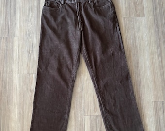 May include: Brown corduroy pants with a classic five-pocket design. The pants have a straight leg cut and a button and zipper closure. The fabric has a textured appearance and a medium-dark brown color.