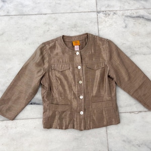 May include: A brown, button-up jacket with a satin-like finish. The jacket has two pockets on the front and a round neckline.