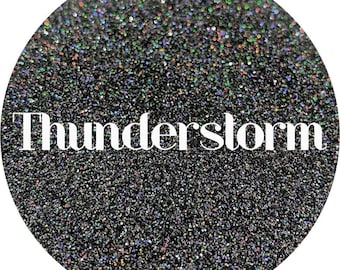 May include: Black glitter with iridescent shimmer, with the word "Thunderstorm" written in white text.