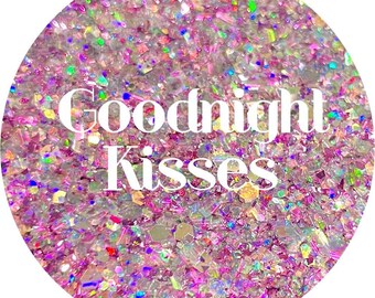 May include: A close-up of iridescent pink and white glitter with the text "Goodnight Kisses" in white.