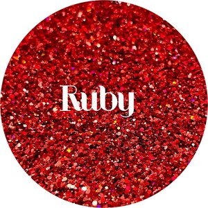 May include: A close-up of red glitter with the word "Ruby" in white text.