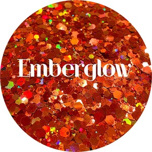 May include: A close-up of a jar of orange, red, and gold glitter with the word "Emberglow" written in white text.