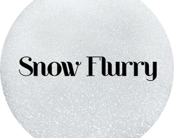 May include: A white glitter background with the text "Snow Flurry" in black.