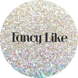 May include: A white iridescent glitter background with the text "Fancy Like" in black.